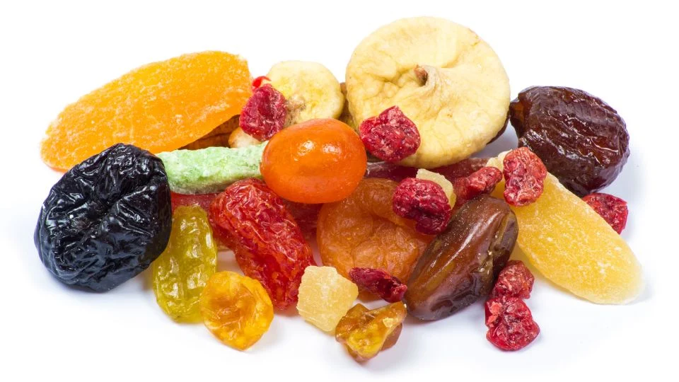 Aszalt gyümölcsök: ízletes és tápláló nassolnivalók Színes aszalt gyümölcsök, mint aszalt sárgabarack, füge és cseresznye, egészséges snack lehetőség.