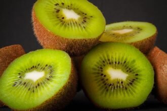 Friss kiwi gyümölcsök, melyek vágva mutatják zöld belsejüket, tele ízzel és tápanyaggal.