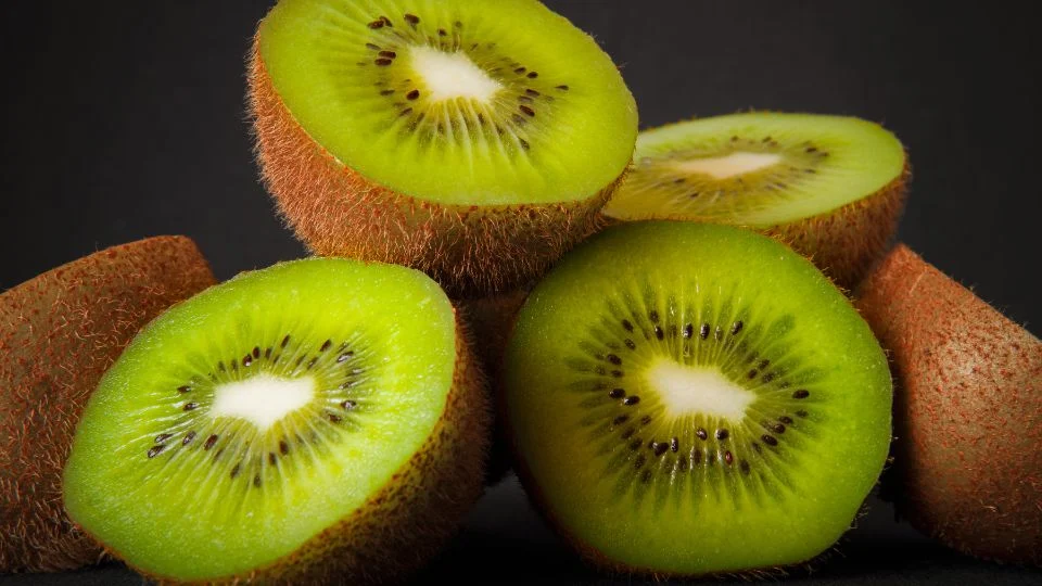 Friss kiwi gyümölcsök, melyek vágva mutatják zöld belsejüket, tele ízzel és tápanyaggal.