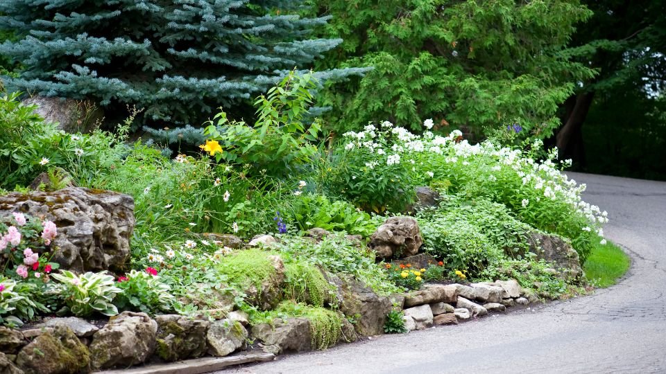 Sziklakert színes virágokkal és zöld növényekkel, barátságos hangulatban.