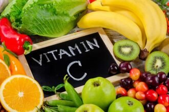 Friss gyümölcsök és zöldségek, köztük narancs, banán, alma, és saláta, vitamin C felirattal.