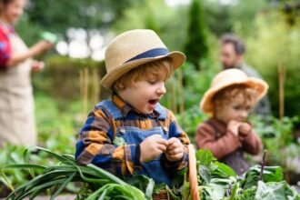 Kisgyerekek kertészkednek, boldogan dolgoznak a növények között.