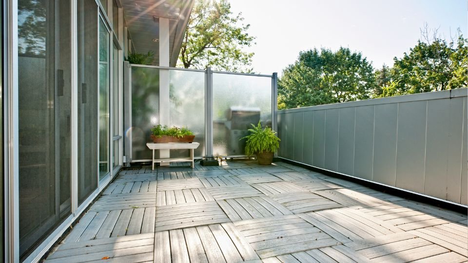 Egy modern erkély, amelyen fák láthatók, barátságos légkörrel.