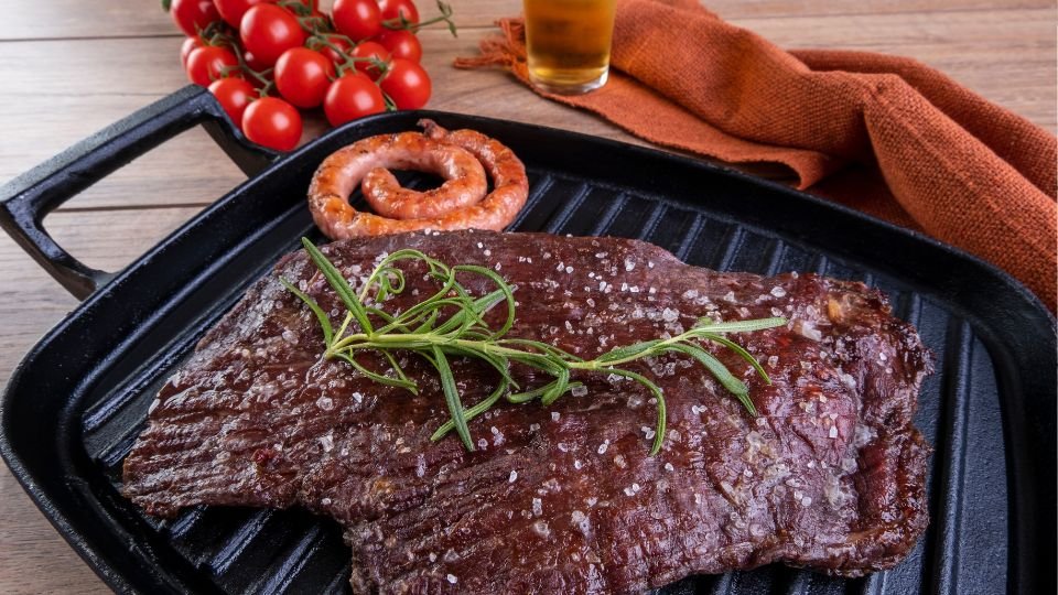 Öntöttvas grill lapon szaftos steak és kolbász, friss fűszerekkel.