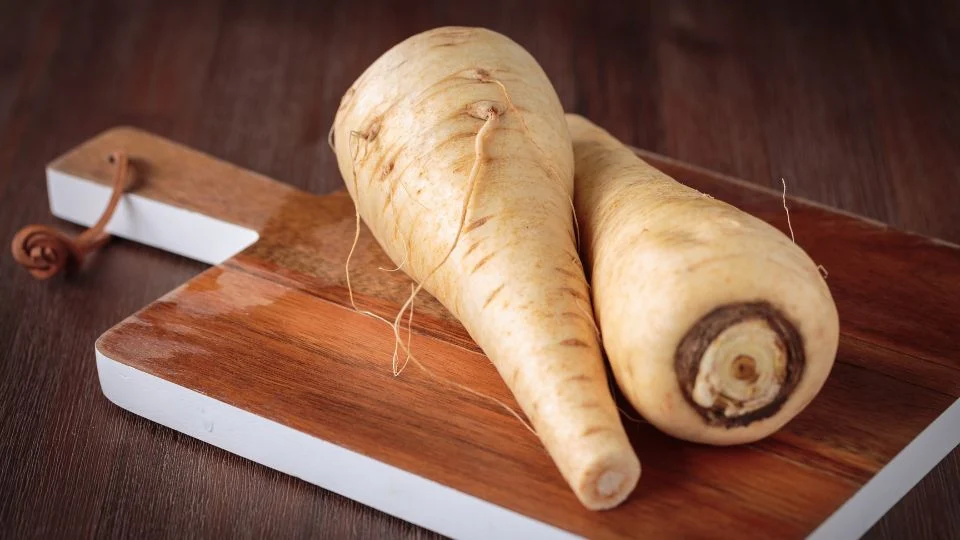 Friss pasztinák vágódeszkán Két friss pasztinák, egy vágódeszkán, természetes környezetben.