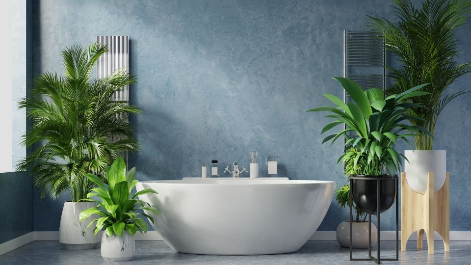 Modern fürdőszoba zöld növényekkel, elegáns kád és kék falak.