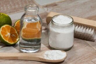 Szódabikarbóna, víz, citrusfélék és egy kefével díszített asztalon.
