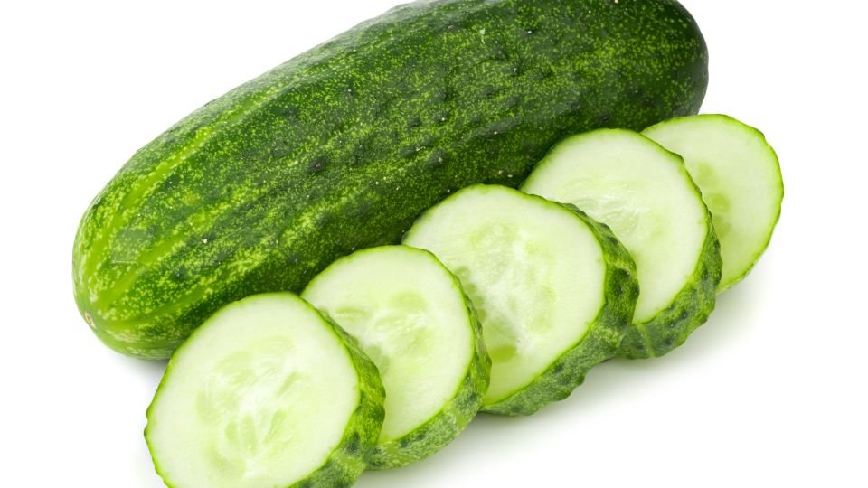 Friss uborka, amely mellett vékonyra szeletelt uborkakarikák láthatók.