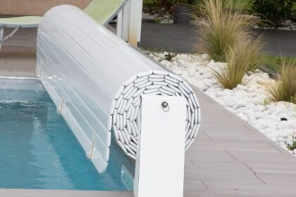 A medence mellett álló fehér medencefedél, amely védi a vizet a szennyeződésektől és csökkenti a párolgást.