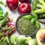 Friss zöldségek és gyümölcsök, köztük zöldborsó, brokkoli, avokádó és alma, színes és vitaminokban gazdag választék.