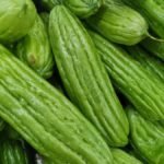 Zöld balzsamkörte gyümölcsök, sima felülettel és hosszúkás formával, egy tálban.