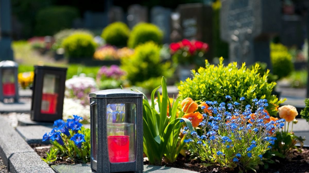 Színes virágok és mécsesek díszítik a sírokat, barátságos és emlékezetes légkört teremtve.